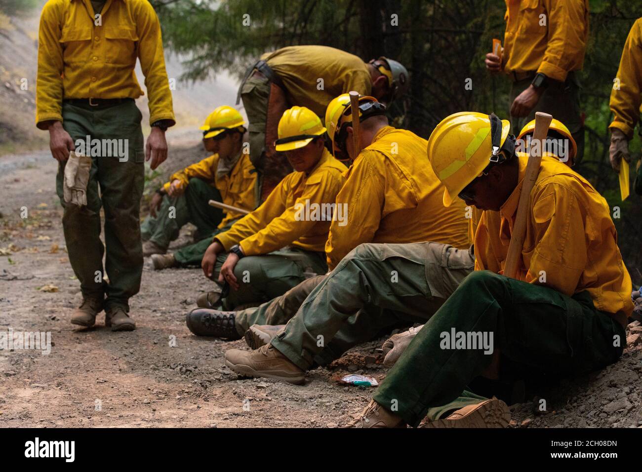 Soldiers with the 14th Brigade Engineer Battalion take a brief respite to sharpen their tools while prepping a road for burnout operations at the August Complex wildland fire on September 6, 2020, in Mendocino National Forest. Burnout involves clearing out easily combustible wildfire fuel such as trees and foliage, helping prevent the wildland fire's spread. Soldiers with the 14th BEB are deployed to Northern California, at the request of the National Interagency Fire Center, in support of Department of Defense wildland firefighting response operations where they work side-by-side with profess Stock Photo