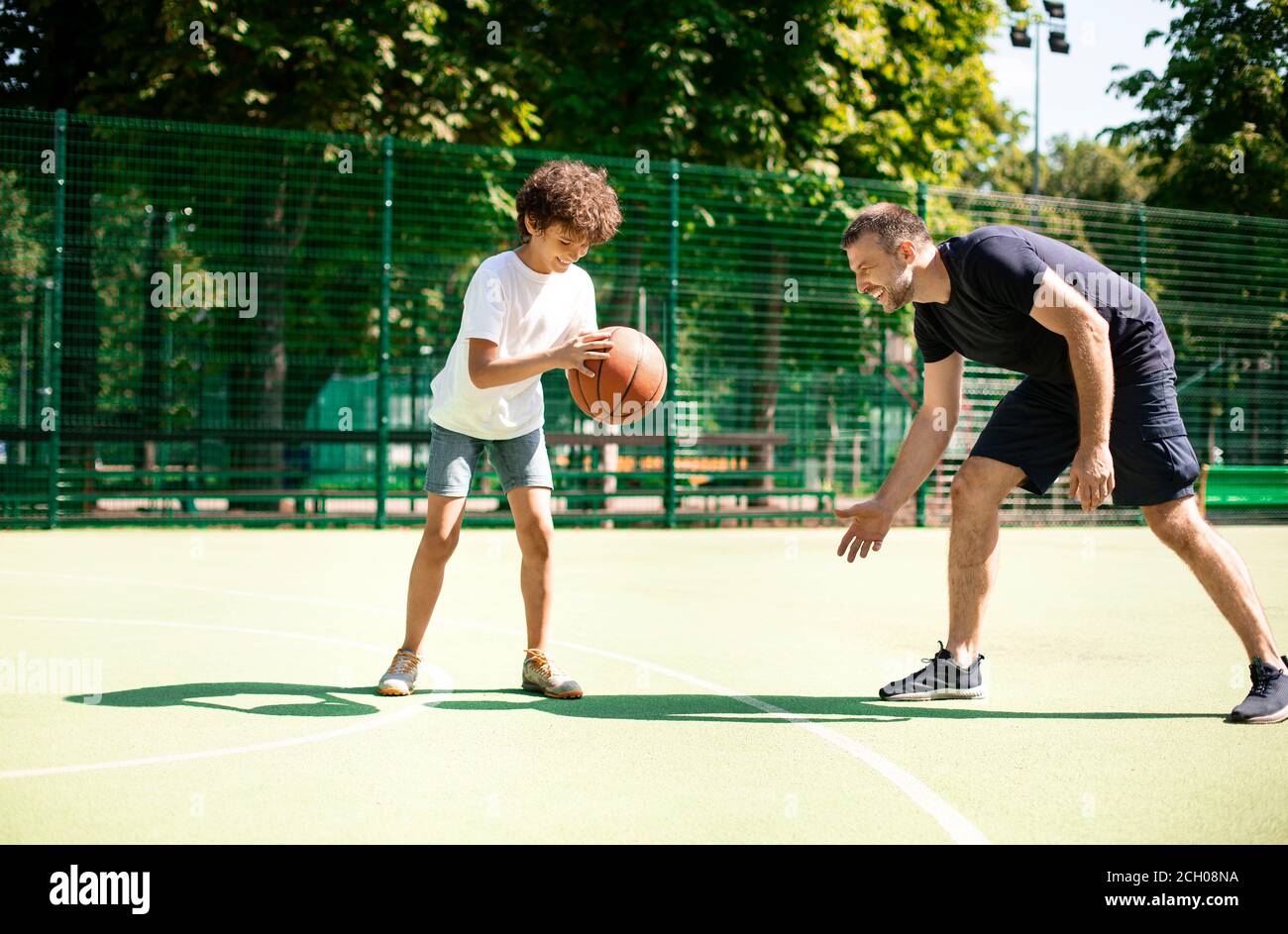 Happy Kids in Basketball Training pratica. Ragazzo che gioca con il basket  durante la sessione di allenamento. Scuola Basket giocatore Holding Ball  Foto stock - Alamy