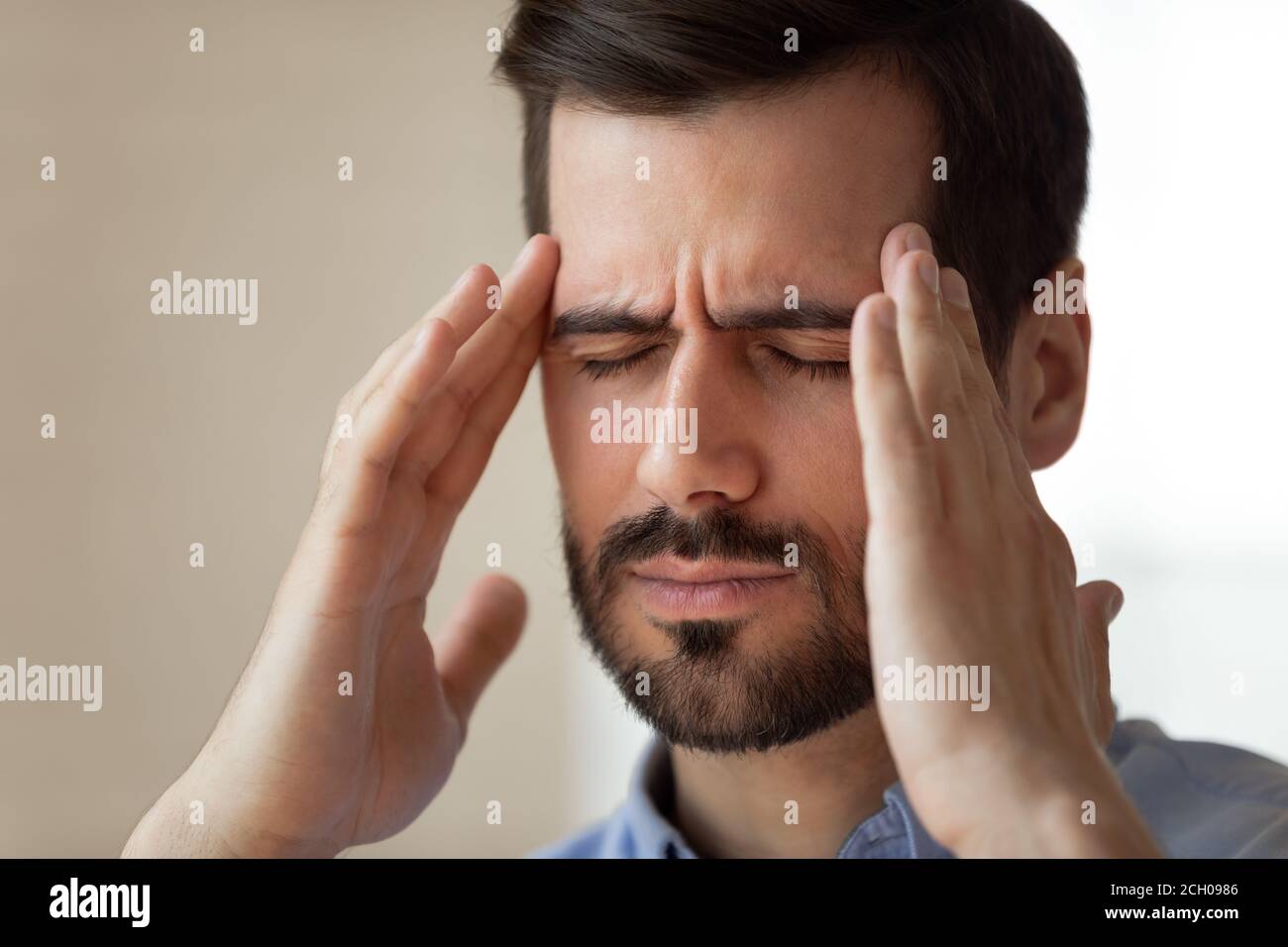 Tired male employee massage head suffering from headache Stock Photo