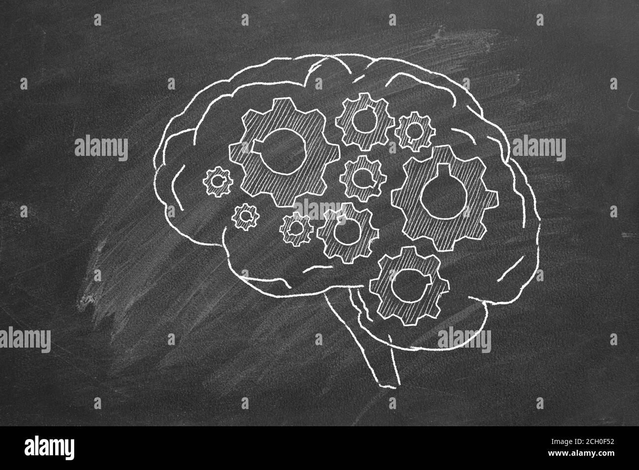 Human brain with cogwheels hand drawn in chalk on a blackboard. Stock Photo