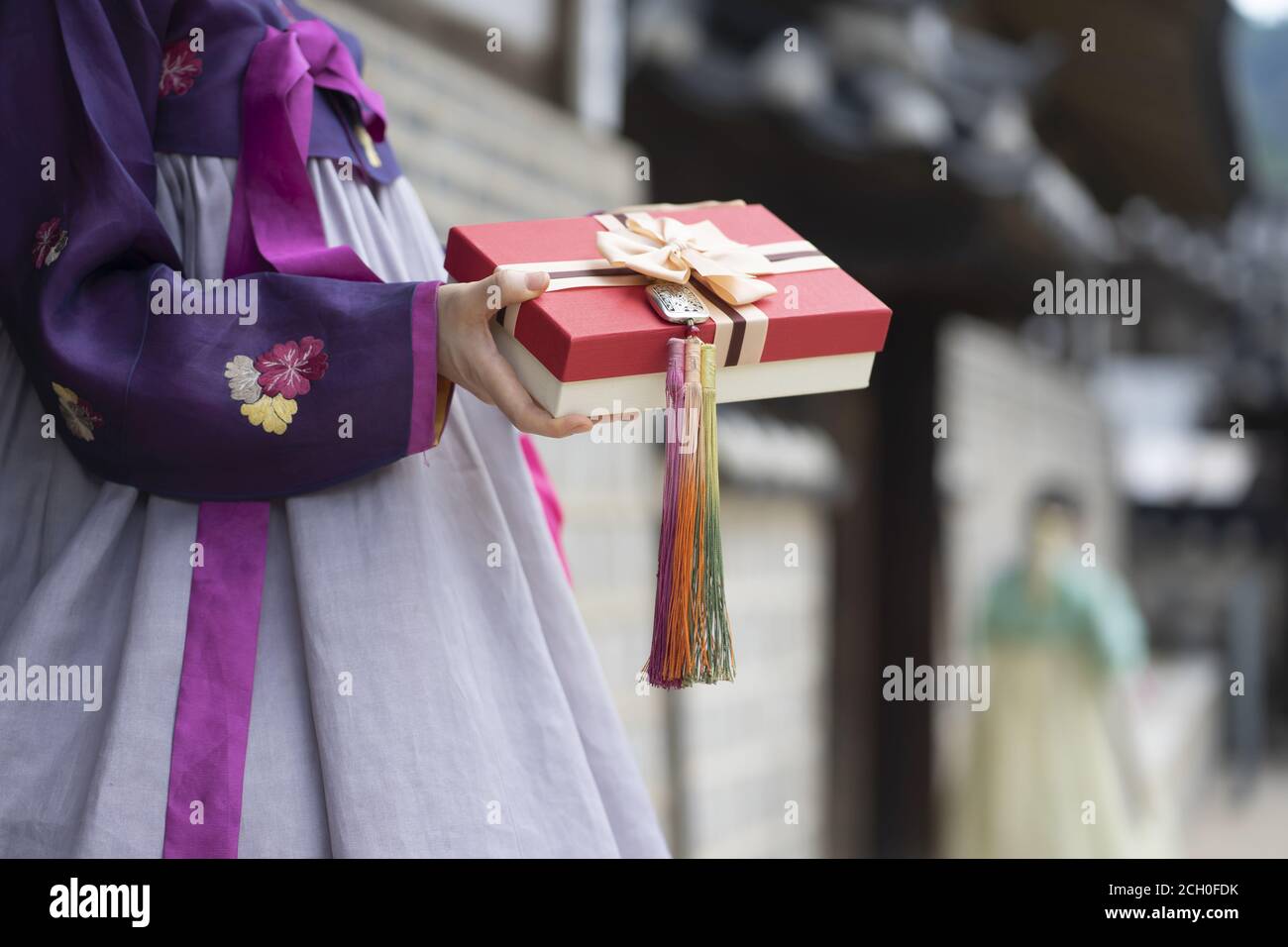 Woman in Korean traditional clothes holding gift box Stock Photo
