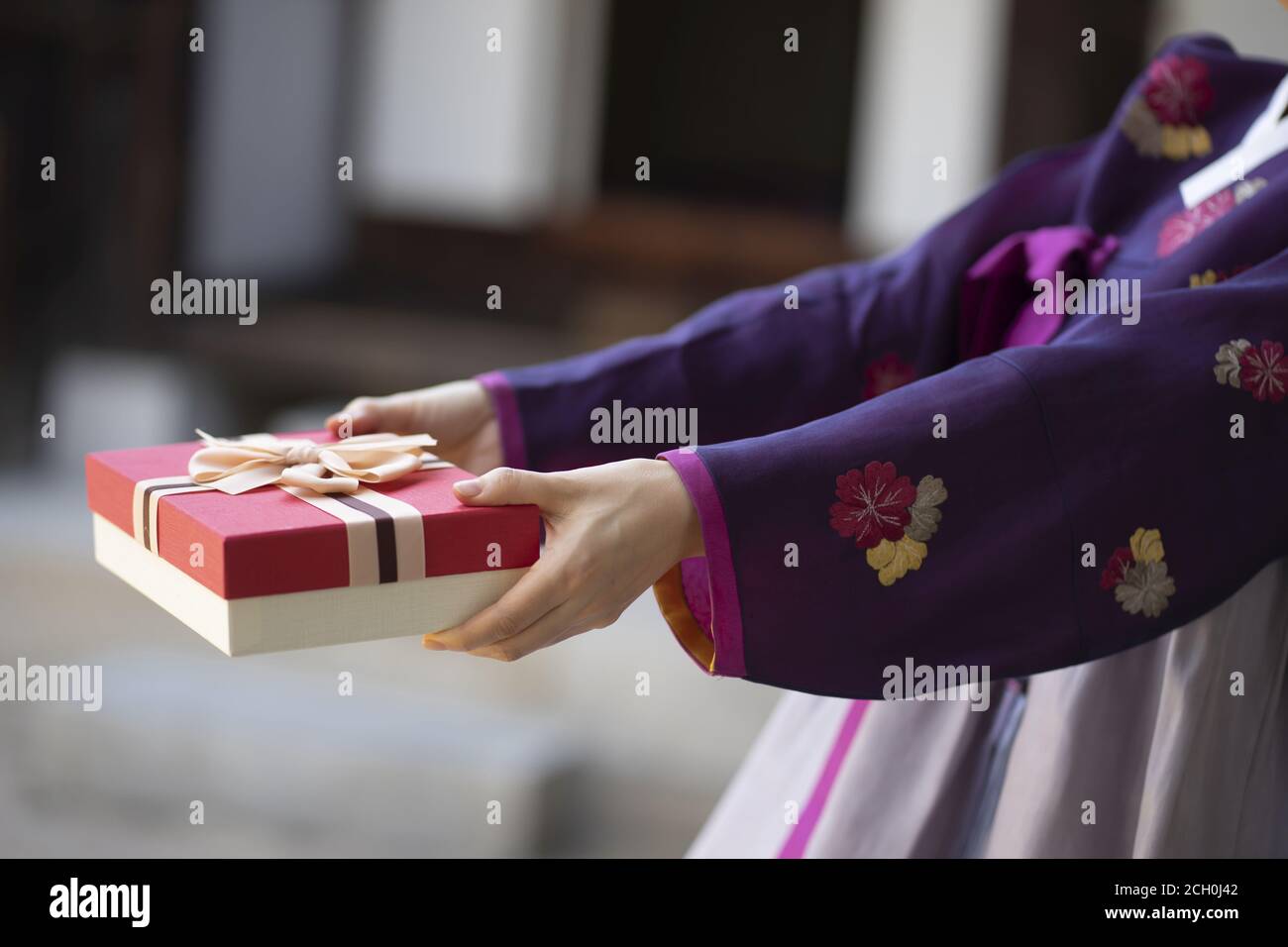 Woman in Korean traditional clothes holding gift box Stock Photo
