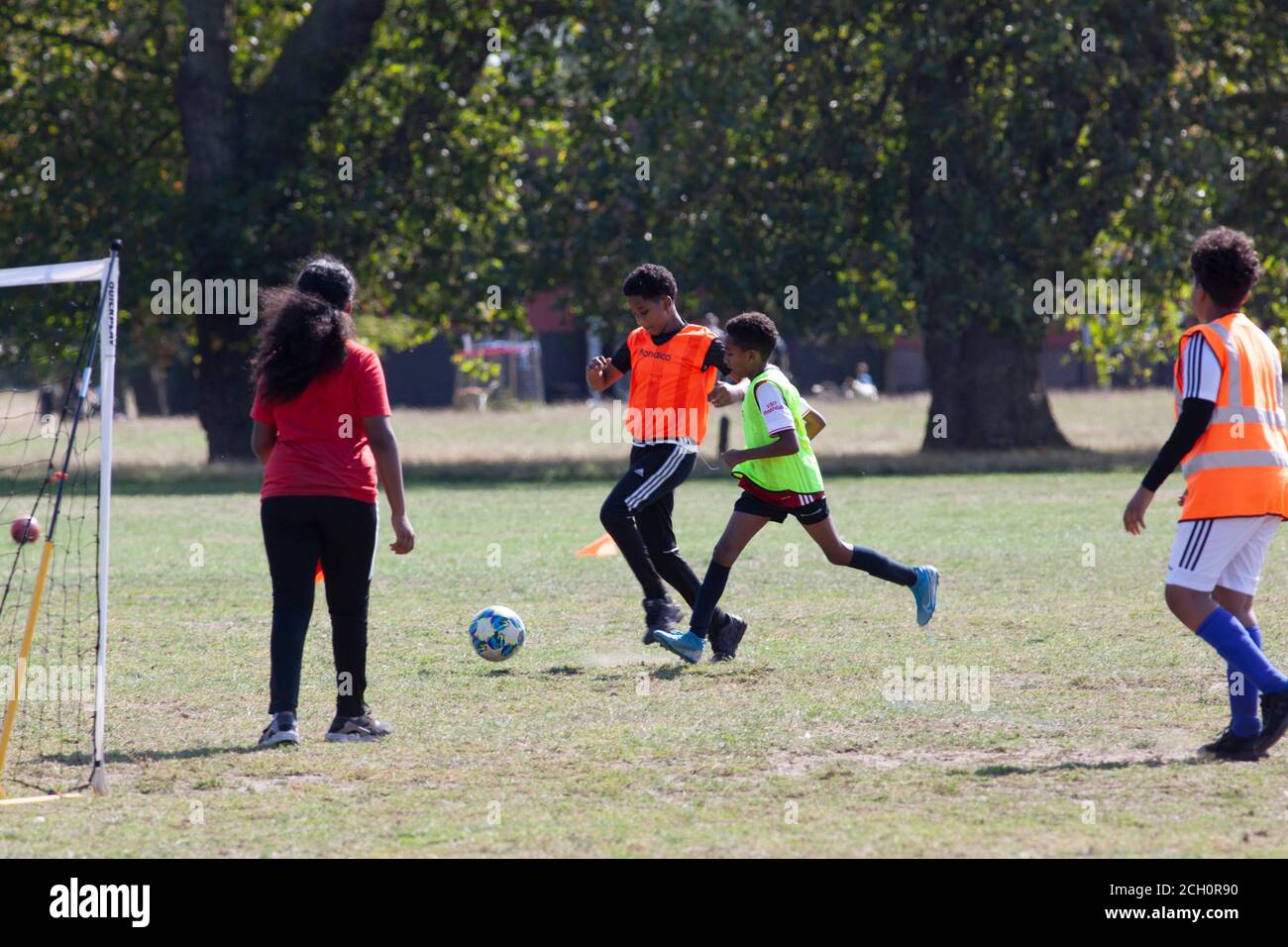 London, UK. 13 Sept 2020: Children took advantage of sunny weather to play football on Clapham Common, London. New laws effective from tomorrow will ban groups of over 6 people meeting but organised sports are exempt from the rule. Anna Watson/Alamy Live News Stock Photo
