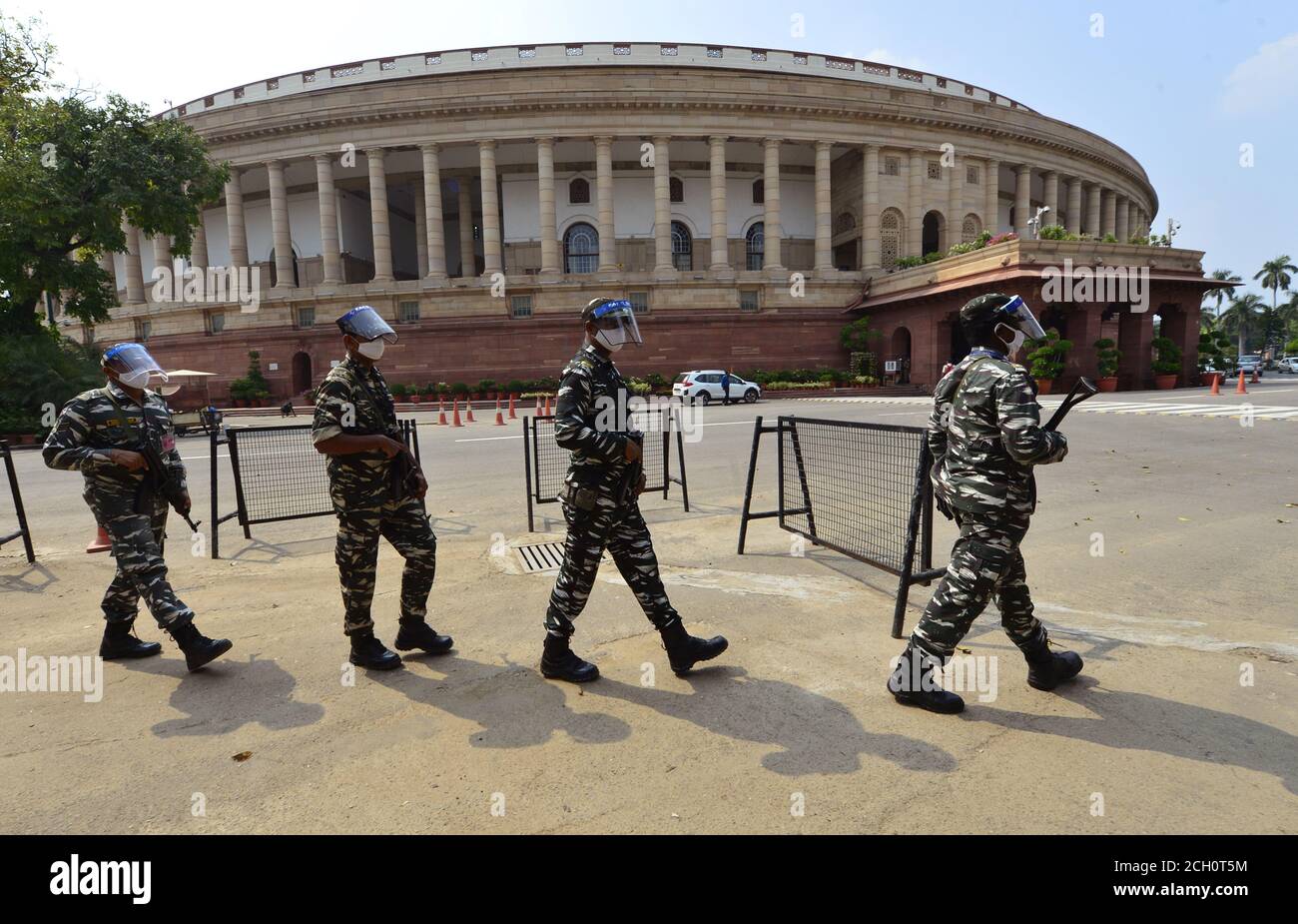 New Delhi, India. 13th September, 2020. Security Personnel wearing face shields and masks patrol the premises of Parliament House, in New Delhi. Parliament is fully prepared for the 18-day Monsoon Session from Monday, Sept. 14, 2020, under the shadow of the coronavirus pandemic with many firsts, including sitting of the two Houses in shifts without any off day, entry only to those having a negative COVID-19 report and compulsory wearing of masks. Credit: PRASOU/Alamy Live News Stock Photo
