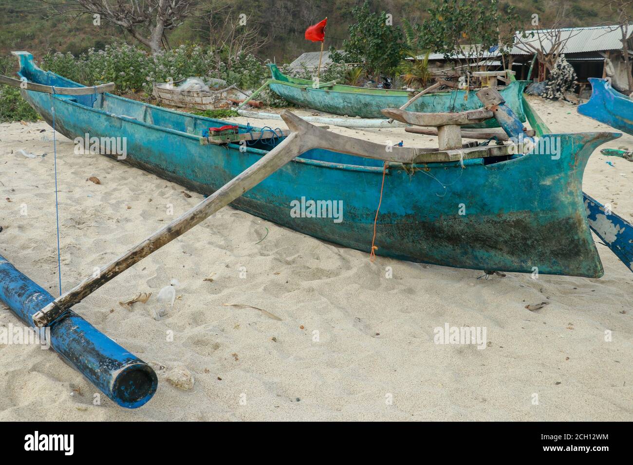 Traditional boat perahu. Wooden fishing boat on a sandy beach Mawun. Blue fishing  boat on the island of Lombok in Indonesia Stock Photo - Alamy