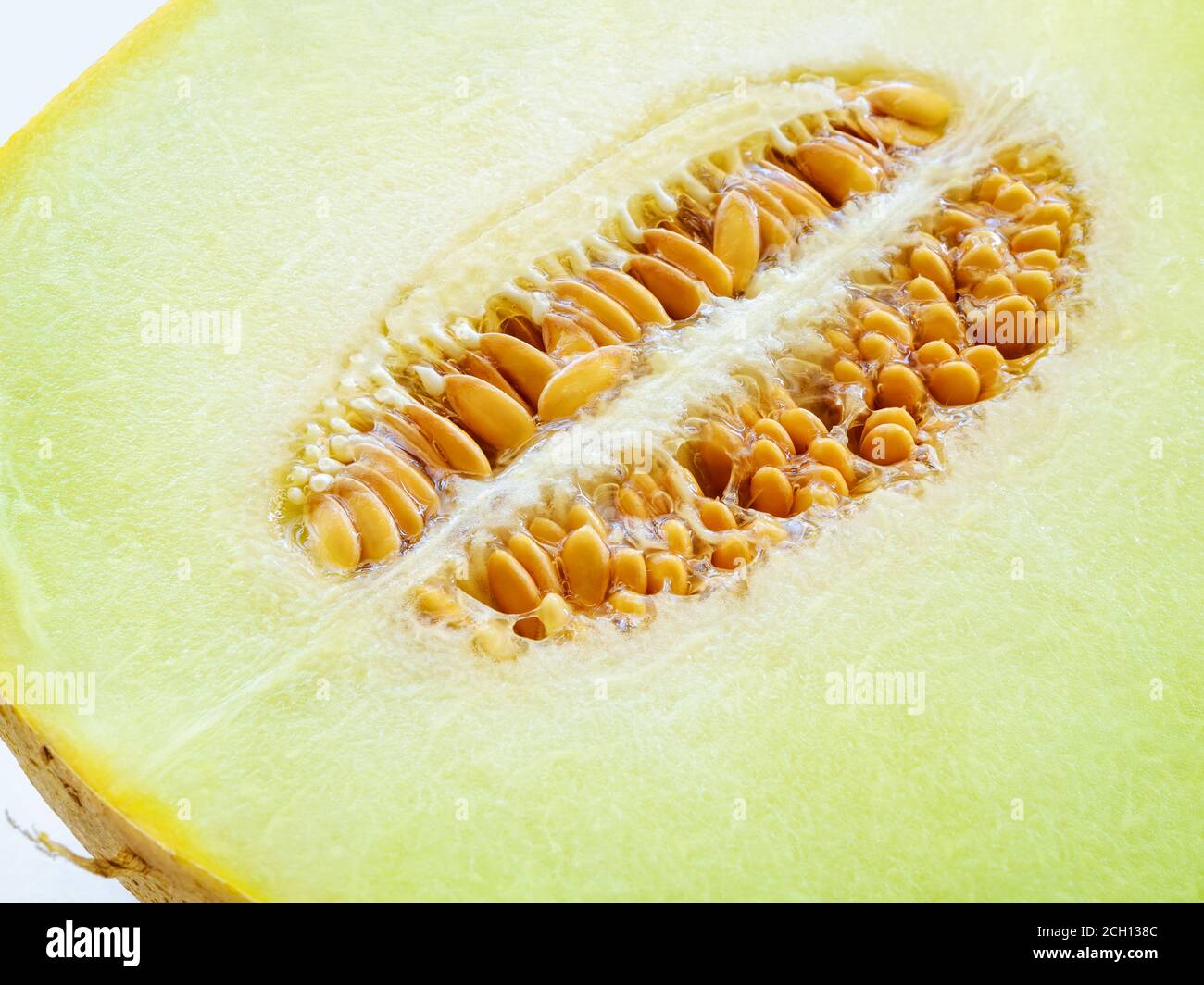 Half of ripe melon with seeds closeup. Sweet green pulp of juicy galia melon. Ingredient for