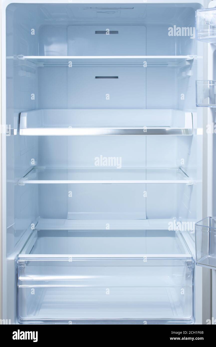 Empty open fridge with shelves, refrigerator. mockup background empty shelves for your products. open fridge shelf. Interior of an empty open white re Stock Photo