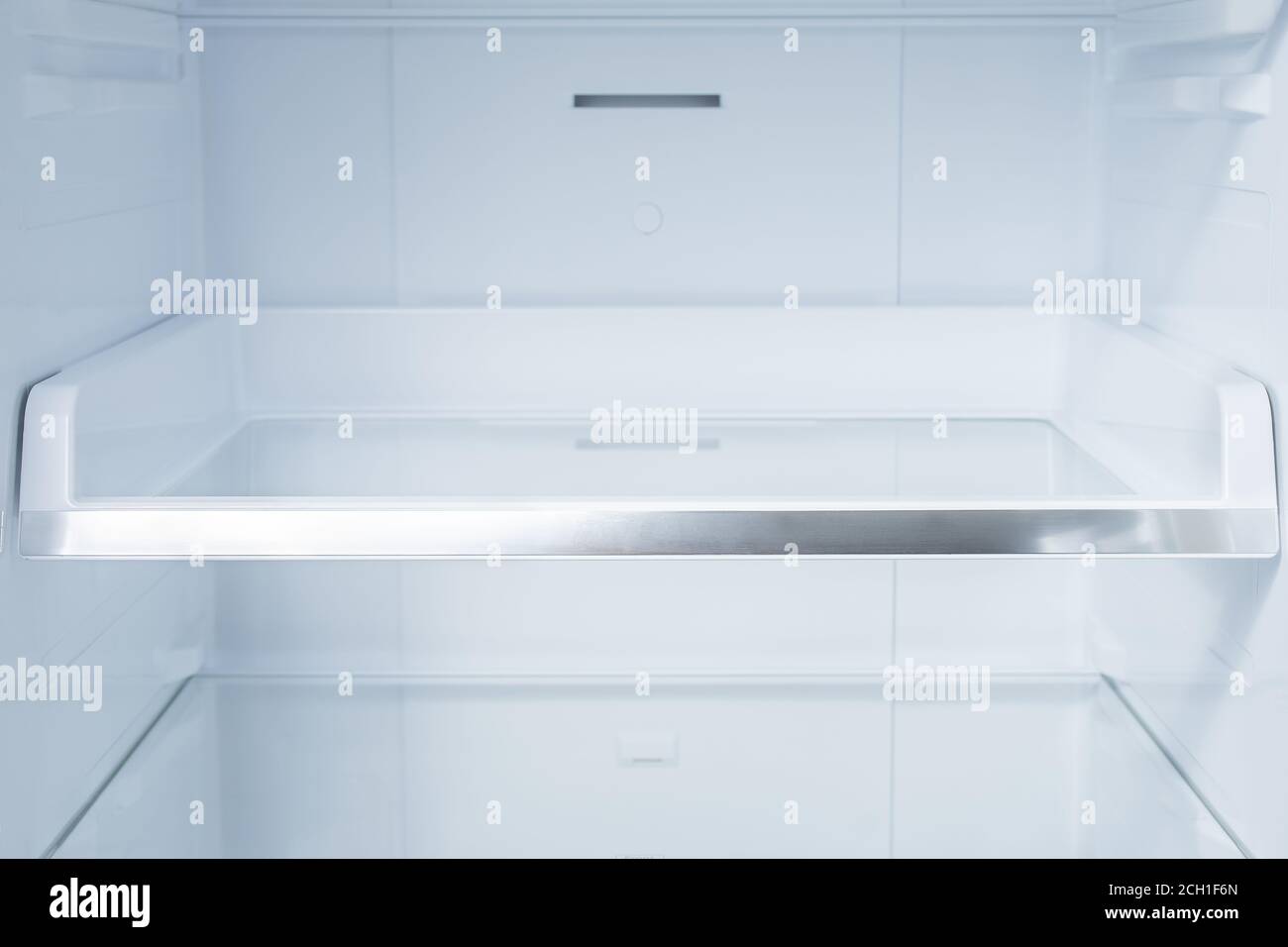 Background empty shelves in the refrigerator. Inside of clean and empty refrigerator with shelves. Shelves in empty open white fridge Stock Photo
