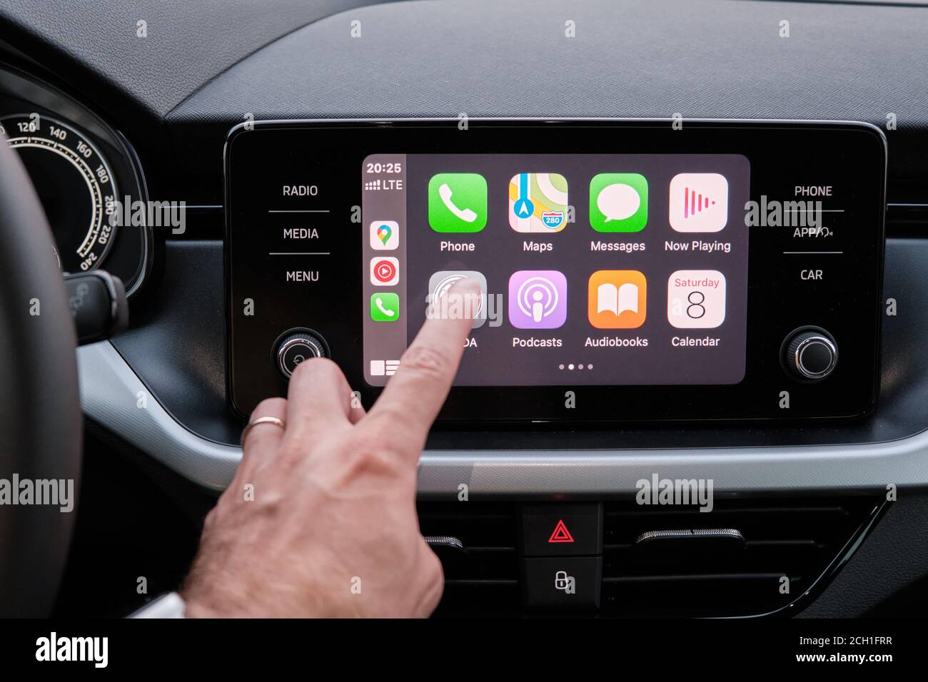 Close up mans hand touching an icon in the Apple Carplay on car