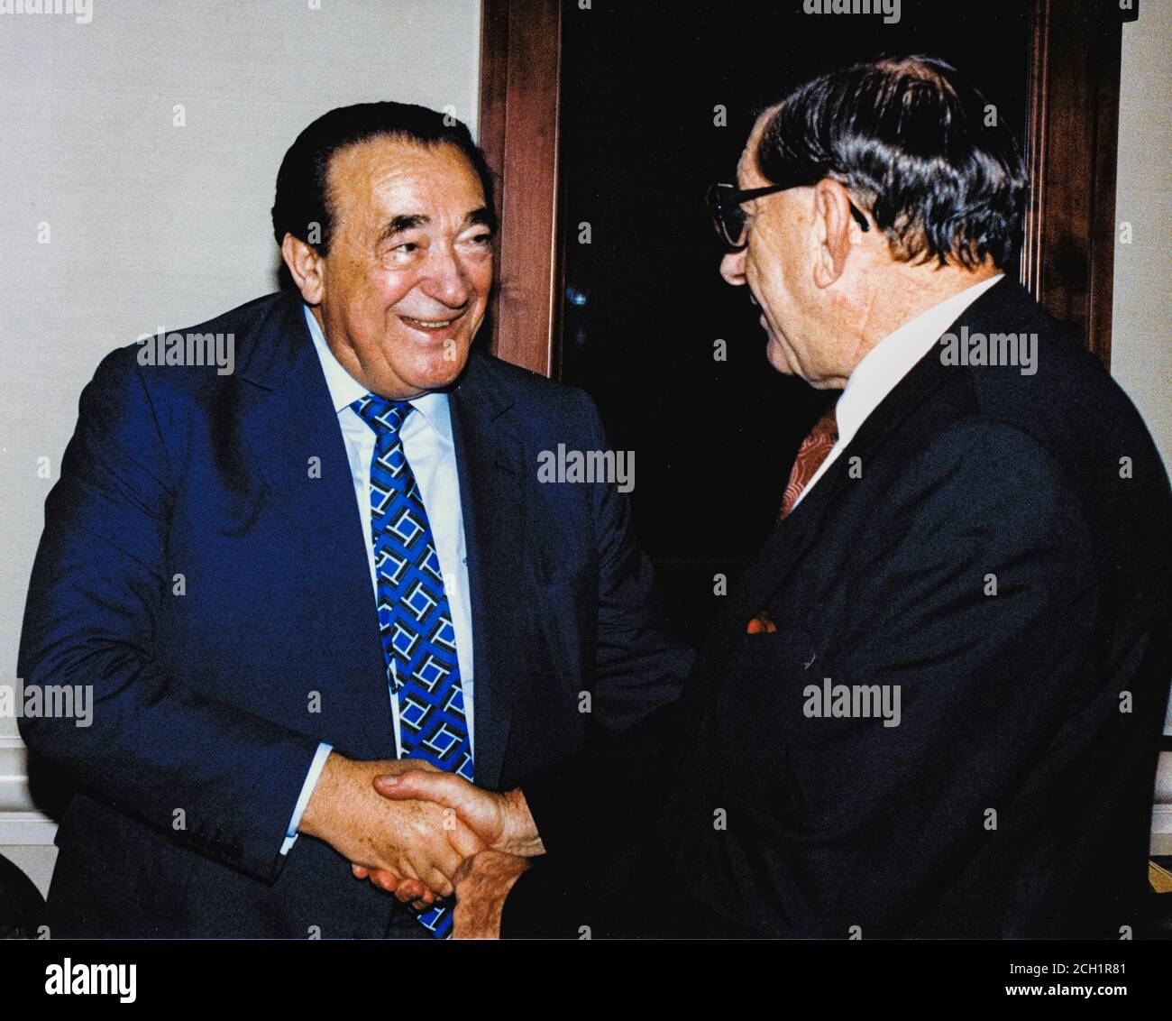 In this file photo from September 25, 1990, disgraced publisher Robert Maxwell, left, meets South African Ambassador to the United States Piet G.J. Koornhof in Washington, DC on September 25, 1990. The New York Post is reporting today that Maxwell, through his daughter Ghislaine Maxwell, may have been the source the huge fortune amassed by alleged pedophile Jeffrey Epstein, who hanged himself in his Manhattan lockup last August.Credit: Ron Sachs/CNP | usage worldwide Stock Photo