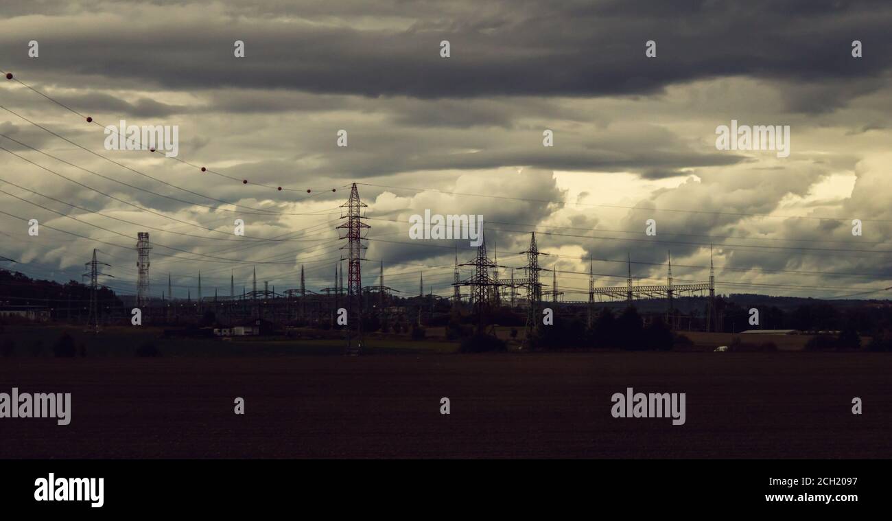 landscape panorama with dramatic overcast sky, high voltage pylons Stock Photo