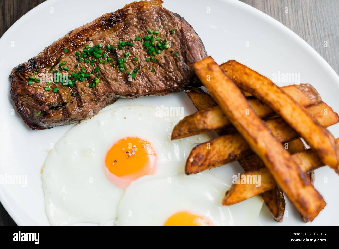 Photo of Grilled Steak with Chunky Potatoes and Fried Egg on a Plate