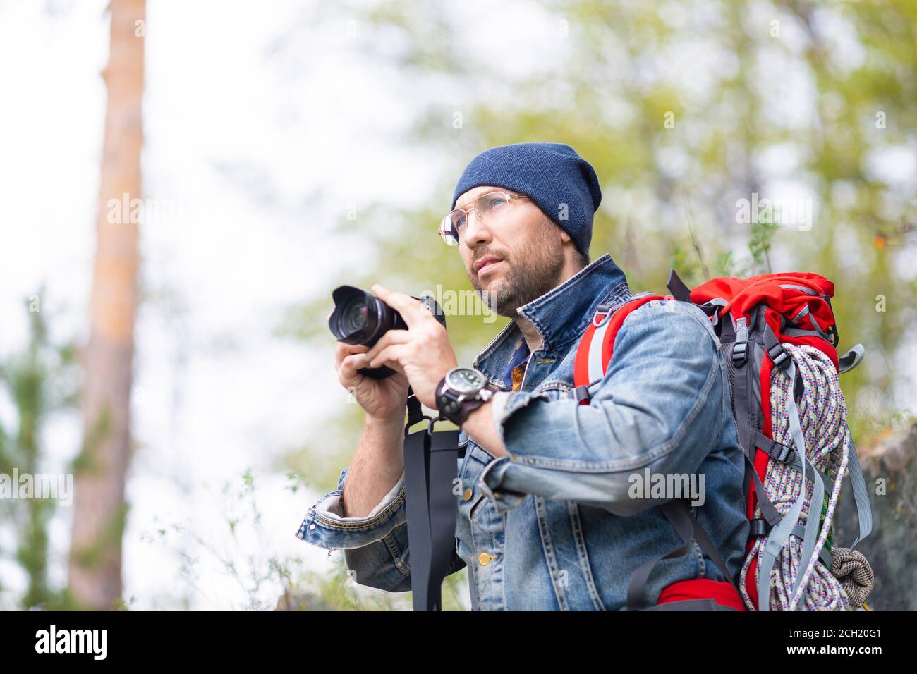 Middle aged bearded male hiker with photocamera. Man going to taking a photo. Stock Photo