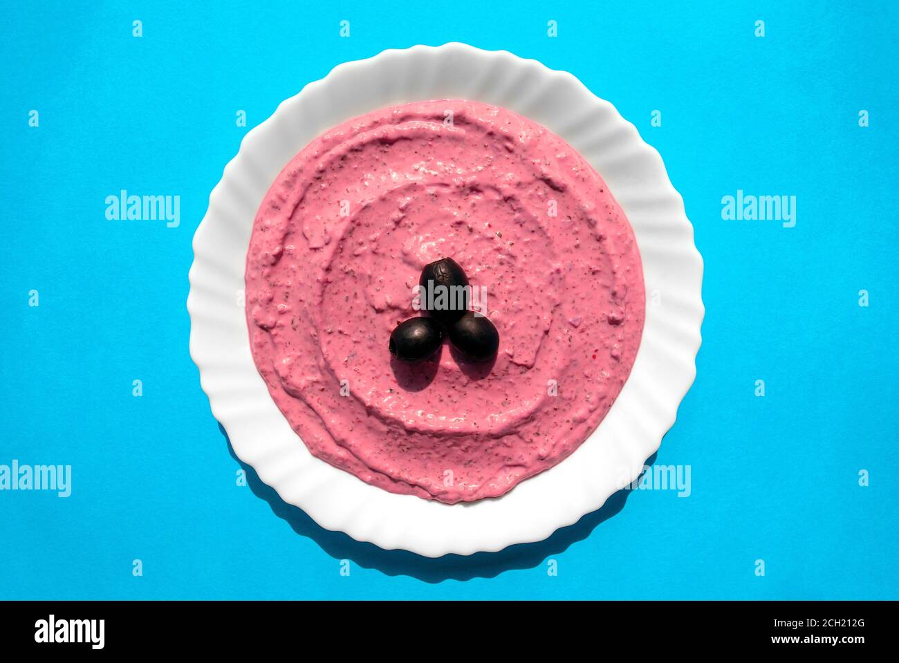 Famous traditional Arabic cuisine Beet hummus in a white plate on