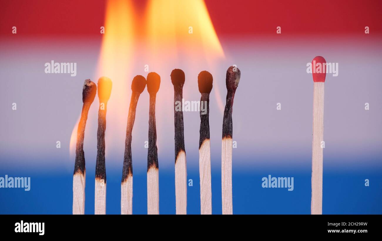 Coronavirus outbreak, social distancing concept. Burning matches on Luxemburg flag background. Concept: spreading virus mechanism. COVID-19 Stock Photo
