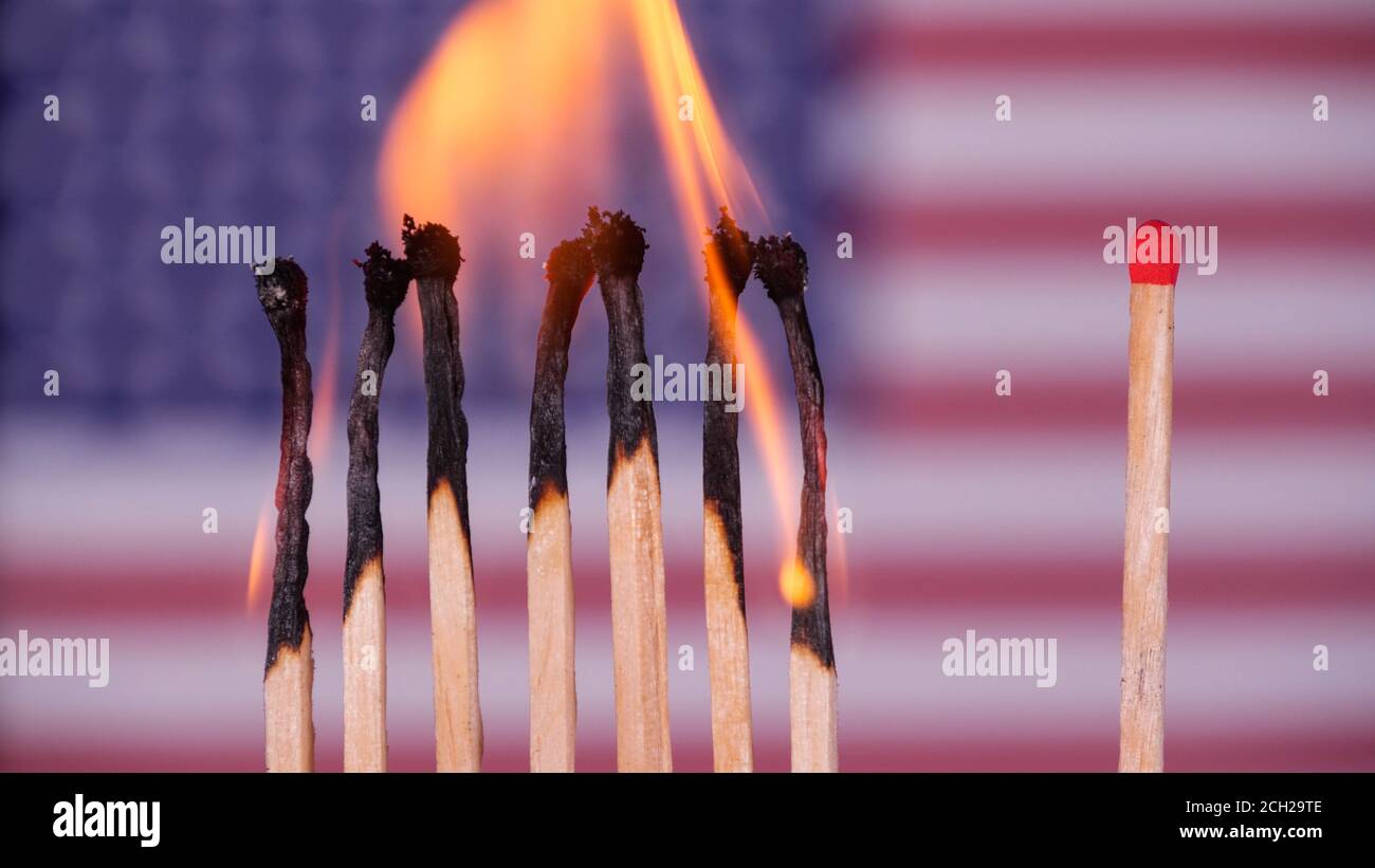Coronavirus outbreak, social distancing concept. Burning matches on USA flag background. Concept: spreading virus mechanism. COVID-19 Stock Photo
