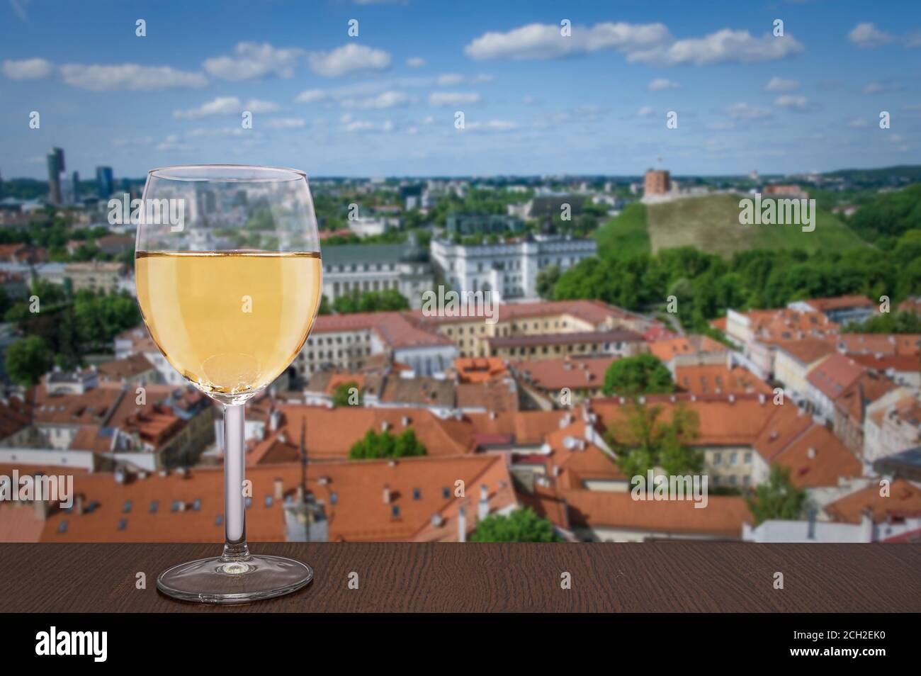 Glass of white wine against Vilnius city center. Vacation concept. View