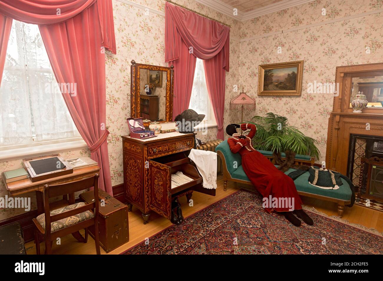 The First Guest Bedroom  in Government House in Regina, Saskatchewan, Canada, reserved for the most important guests.The house was used as the official residence of the Lieutenant Governors of the NW Territories and later, the province of Saskatchewan until 1945. The furnishings and clothing are chosen to represent the time of Lieutenant Governor Amedee Forget (1898-1910). The 'fainting couch' was used by women since, after age 13, they wore such tight corsets (seen on the footstool) that it was often hard to catch one's breath. Property release not needed because this museum is owned by the C Stock Photo