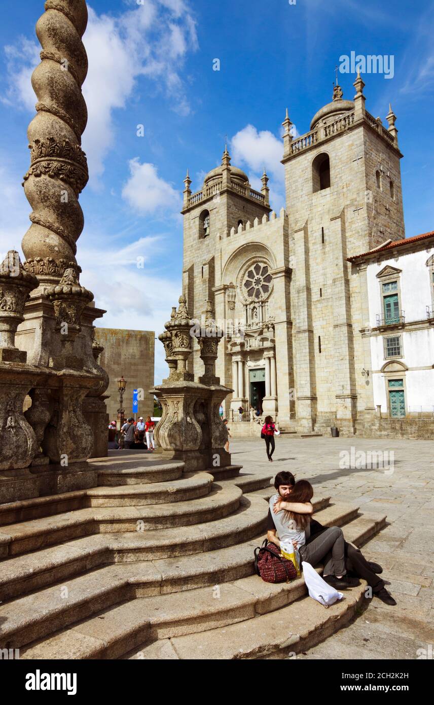 Porto, Portugal : A young couple hugs next to the Porto Cathedral, built in the 12th century, with Baroque and 20th century modifications. Stock Photo