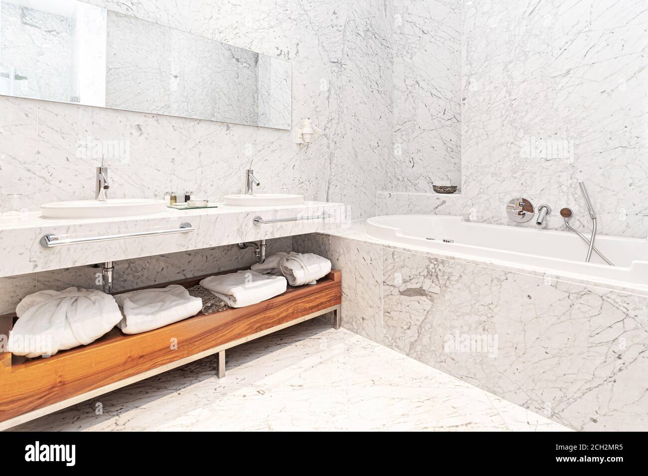 beautiful interior of a modern white marble hotel batroom with bathtube ...