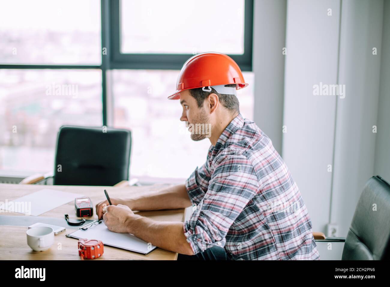 construction worker is writing the length and wideth of the model on