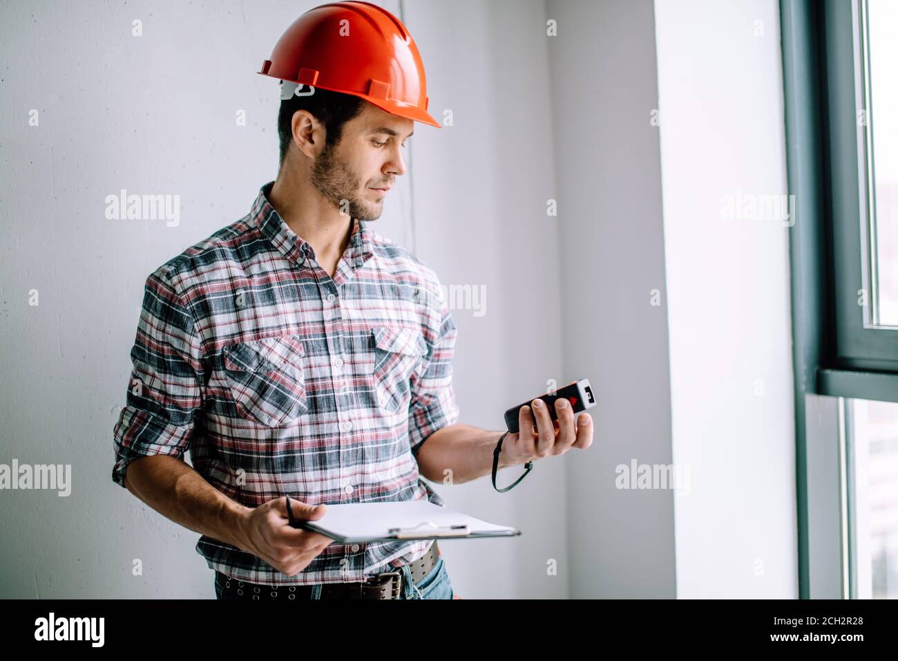constructor is using the tape measure during work. close up side view photo. equipment concept Stock Photo
