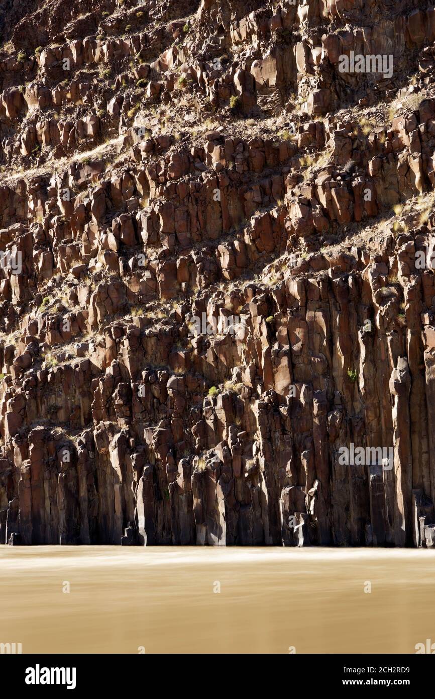 John Day River flowing under columnar basalt rock cliffs, central Oregon desert, USA Stock Photo