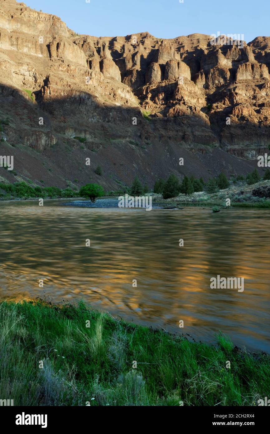 Basalt cliffs reflected on John Day River at sunrise, central Oregon desert, Oregon, USA Stock Photo