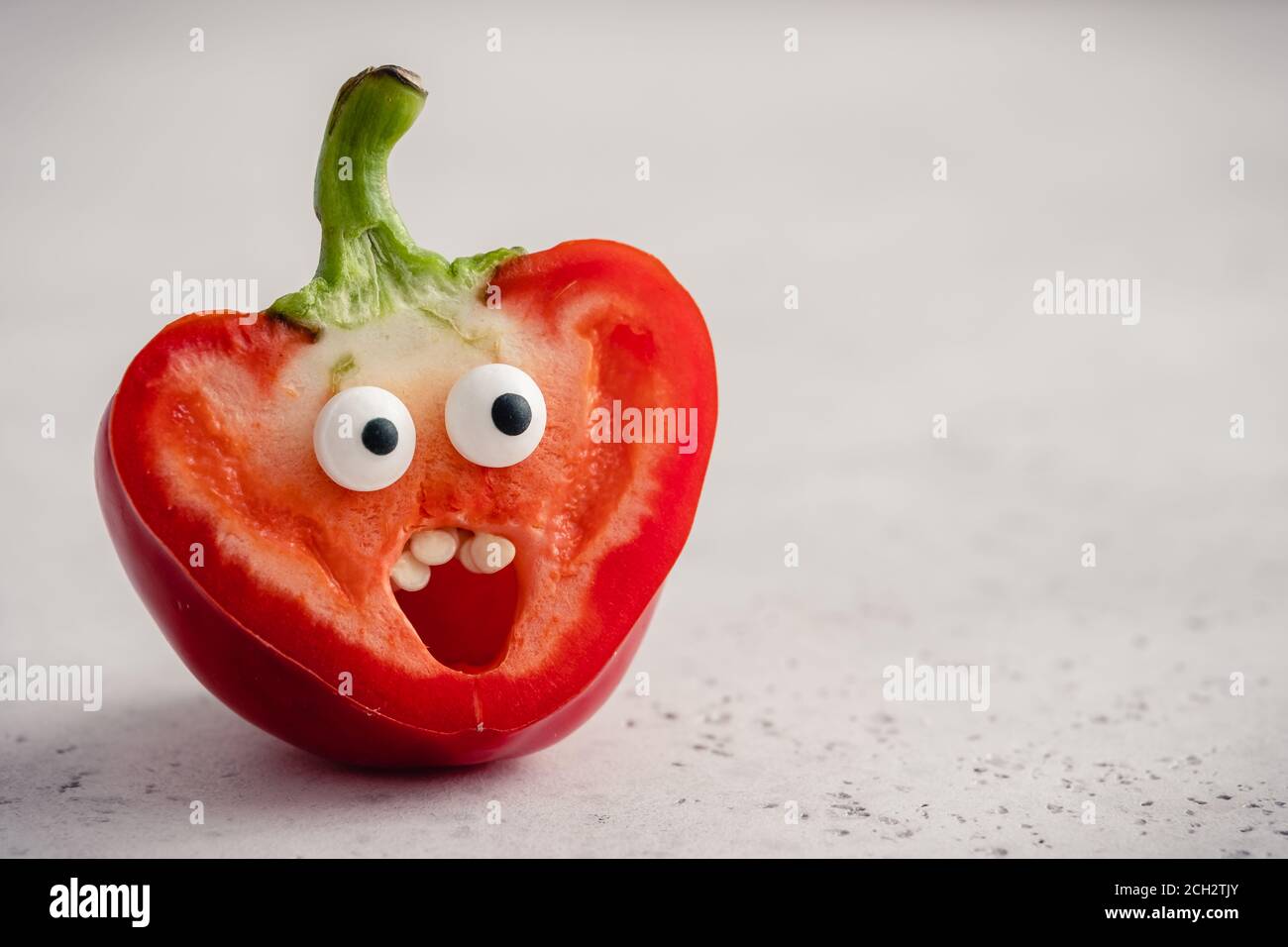 Pepper with funny face. Surprised pepper with Googly eyes over white
