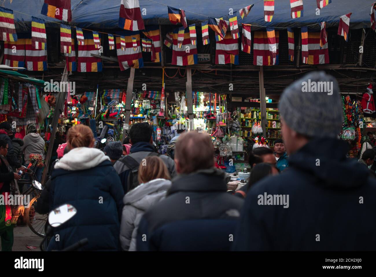 Kathmandu, Nepal - December 22 2019: Unidentified people walks by different shops on the street with colorful flags above on December 22 in Kathmandu Stock Photo