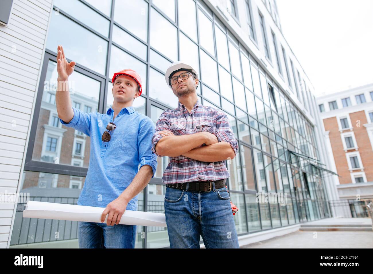 talented engineer with blueprint is showing the new neighbourhood to a ...