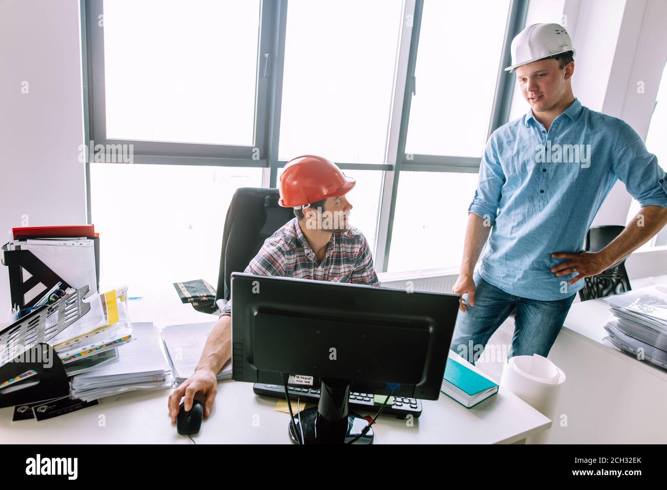 experiensed engineer is teaching a new colleague working on the computer. technology concept Stock Photo