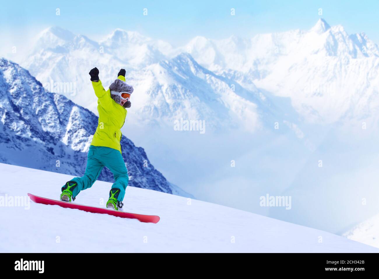 Girl snowboarder running down the slope in Alpine mountains. Winter sport and recreation, leisure outdoor activities. Image of excited screaming young Stock Photo