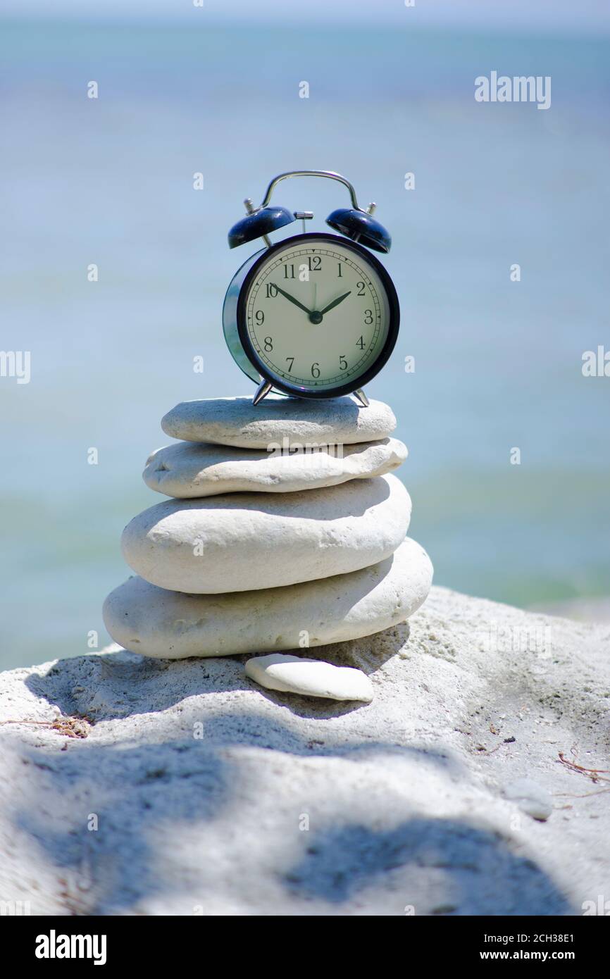 ALARM CLOCK AT THE BEACH ON BALANCING ROCKS. CONCEPT OF MEDITATION AND ZEN  TIME AT THE BEACH Stock Photo - Alamy