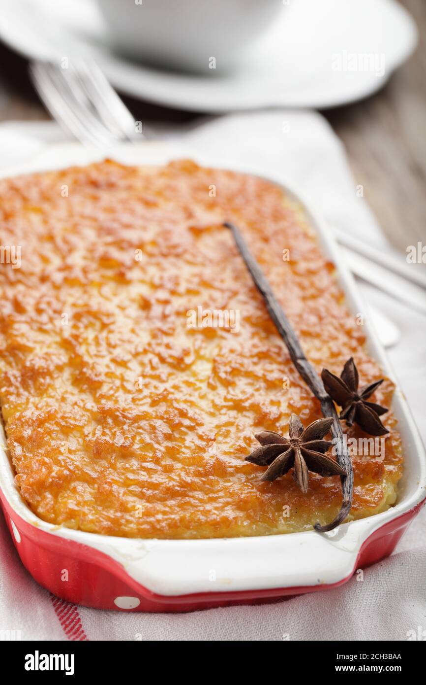 Rice pudding in a baking dish decorated with vanilla stick and anise Stock Photo