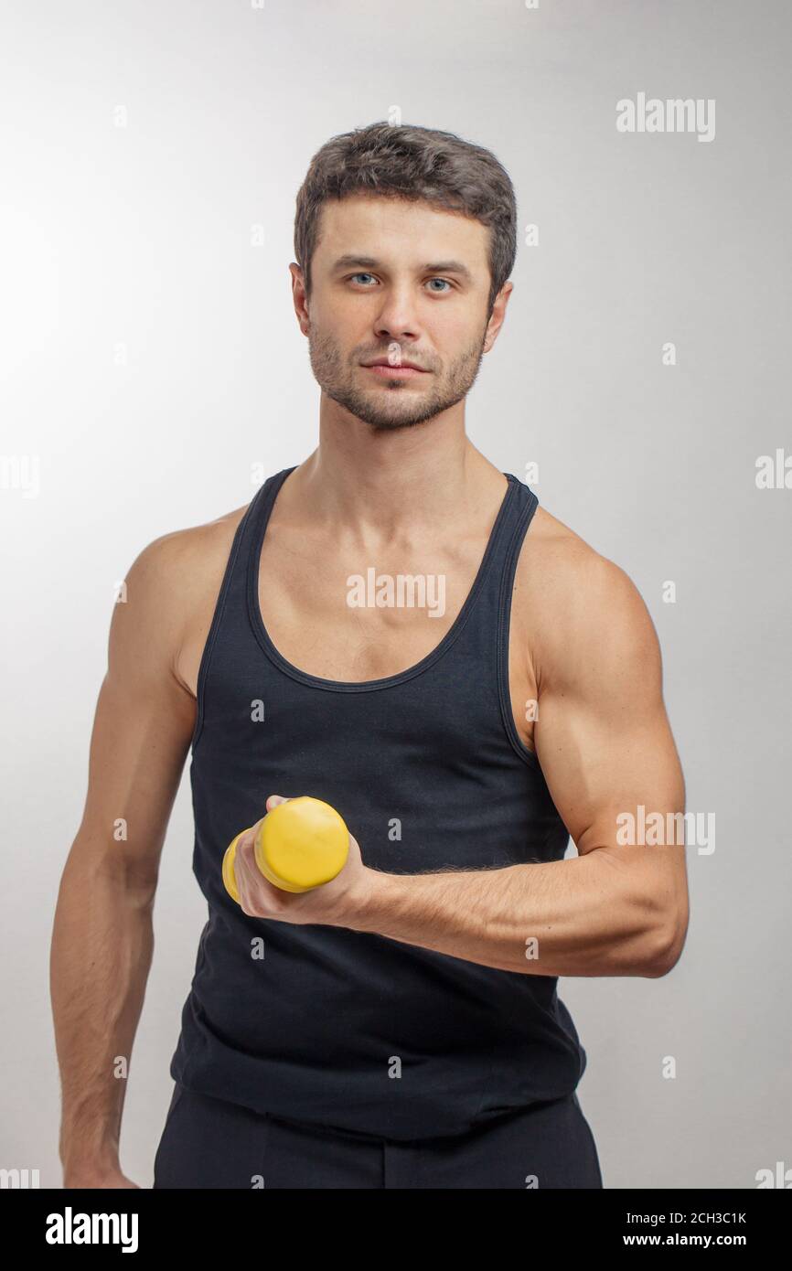 well-built-handsome-guy-with-yellow-dumbbell-posing-to-the-camera-stock