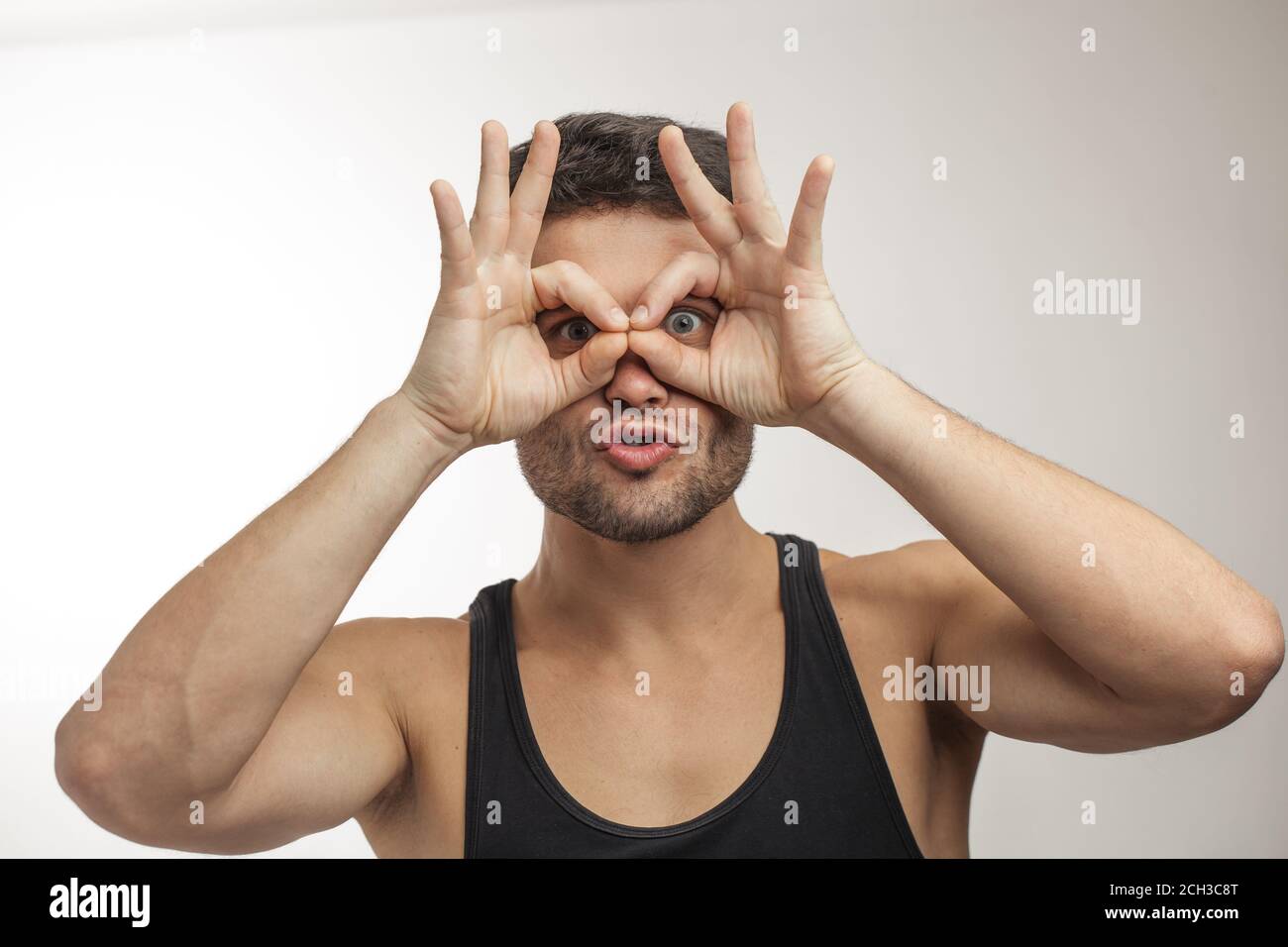 funny man is looking through glasses from fingers Stock Photo