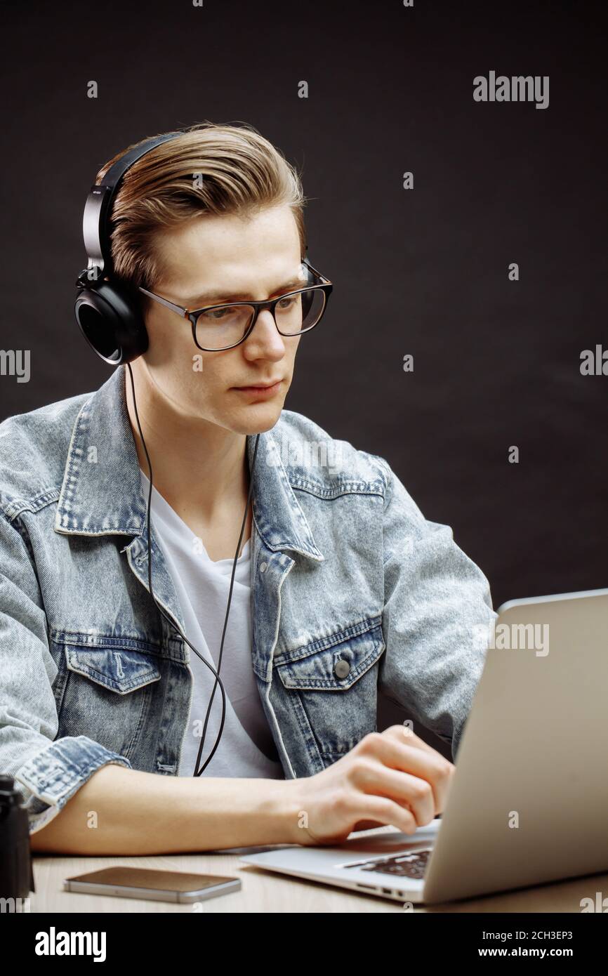 serious rewriter in denim jacket working with computer Stock Photo