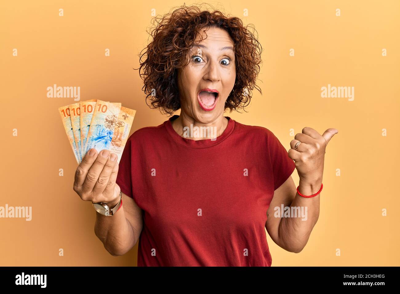 Beautiful middle age mature woman holding 10 swiss franc banknotes ...