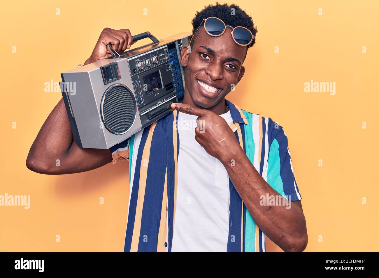 Young african american man holding boombox, listening to music smiling  happy pointing with hand and finger Stock Photo - Alamy