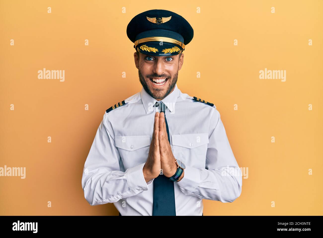 Pilot Praying On Ramp Handsome hispanic man wearing airplane pilot uniform praying with hands ...