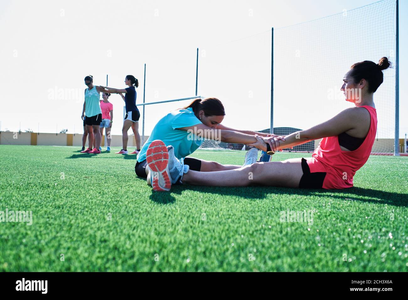 group of young women practice stretching after their training Stock Photo