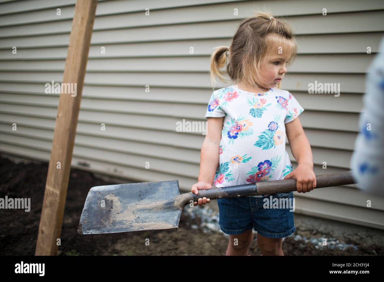 Cute girl holding shovel in backyard Stock Photo Alamy