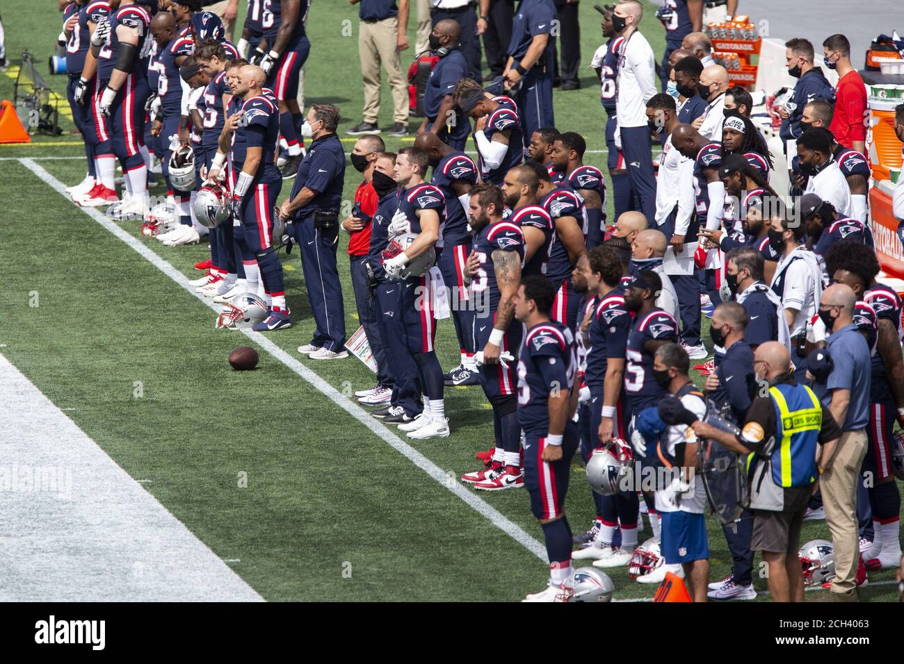 Foxborough, United States. 13th Sep, 2020. New England Patriots coaches and  players line up for the National Anthem at the start of the game against  Miami Dolphins at Gillette Stadium in Foxborough,