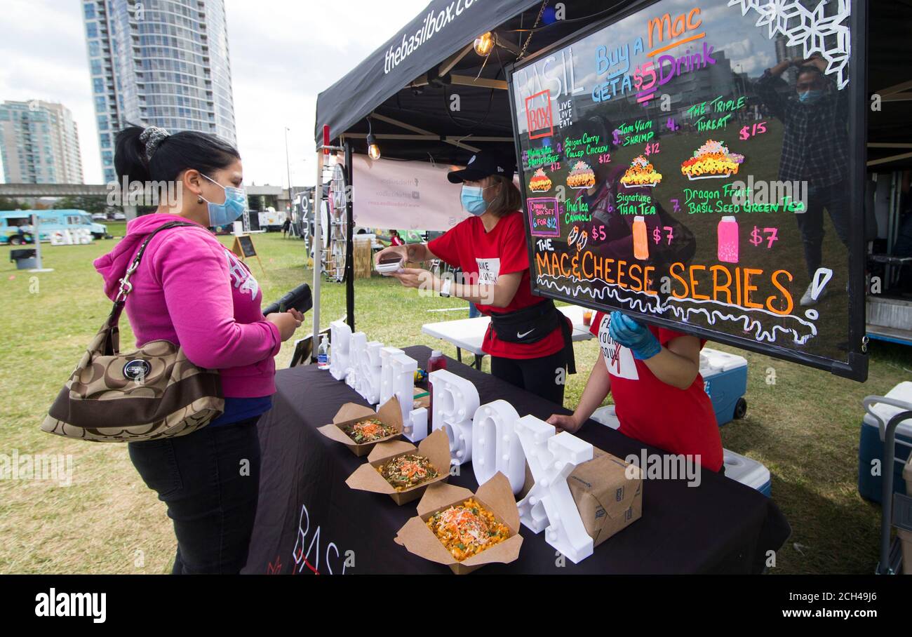 Toronto, Canada. 13th Sep, 2020. A woman (L) wearing a face mask buys