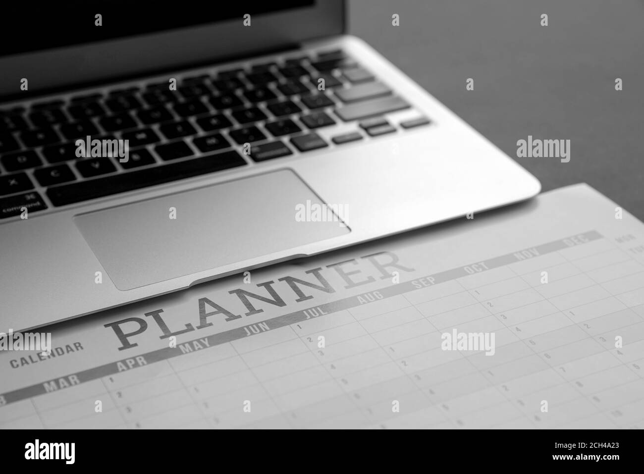 Computer laptop on top of calendar planner. Soft focus, Business planning concept. Stock Photo