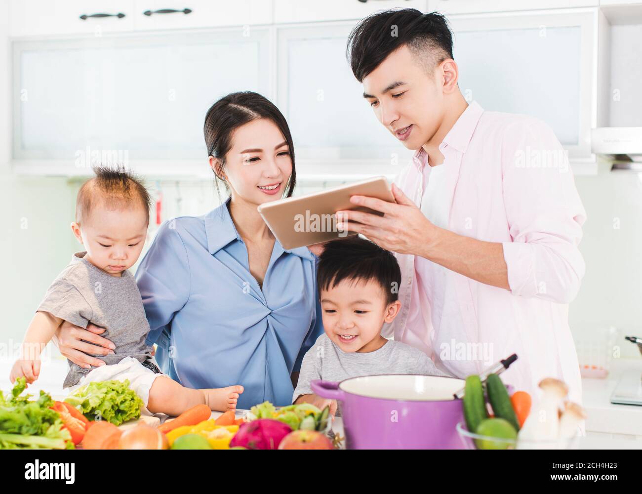 happy family preparing dinner with healthy  food in kitchen Stock Photo