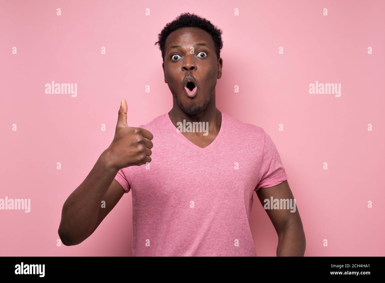 Surprised handsome black man showing thumb up giving advice Stock Photo