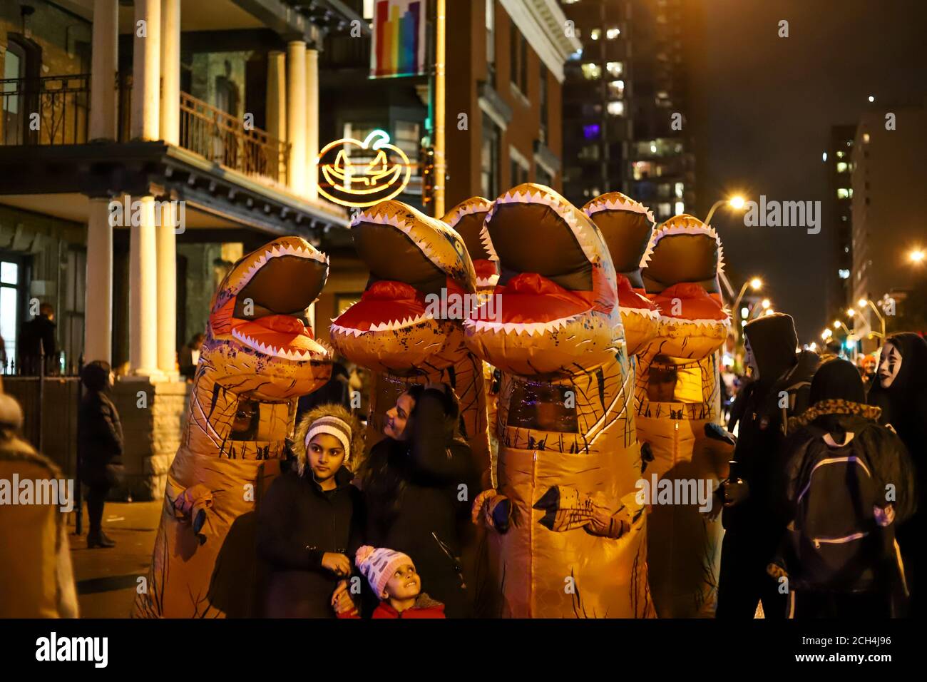 Halloween night carnival . Church street, people walking in different masks and costumes. Stock Photo