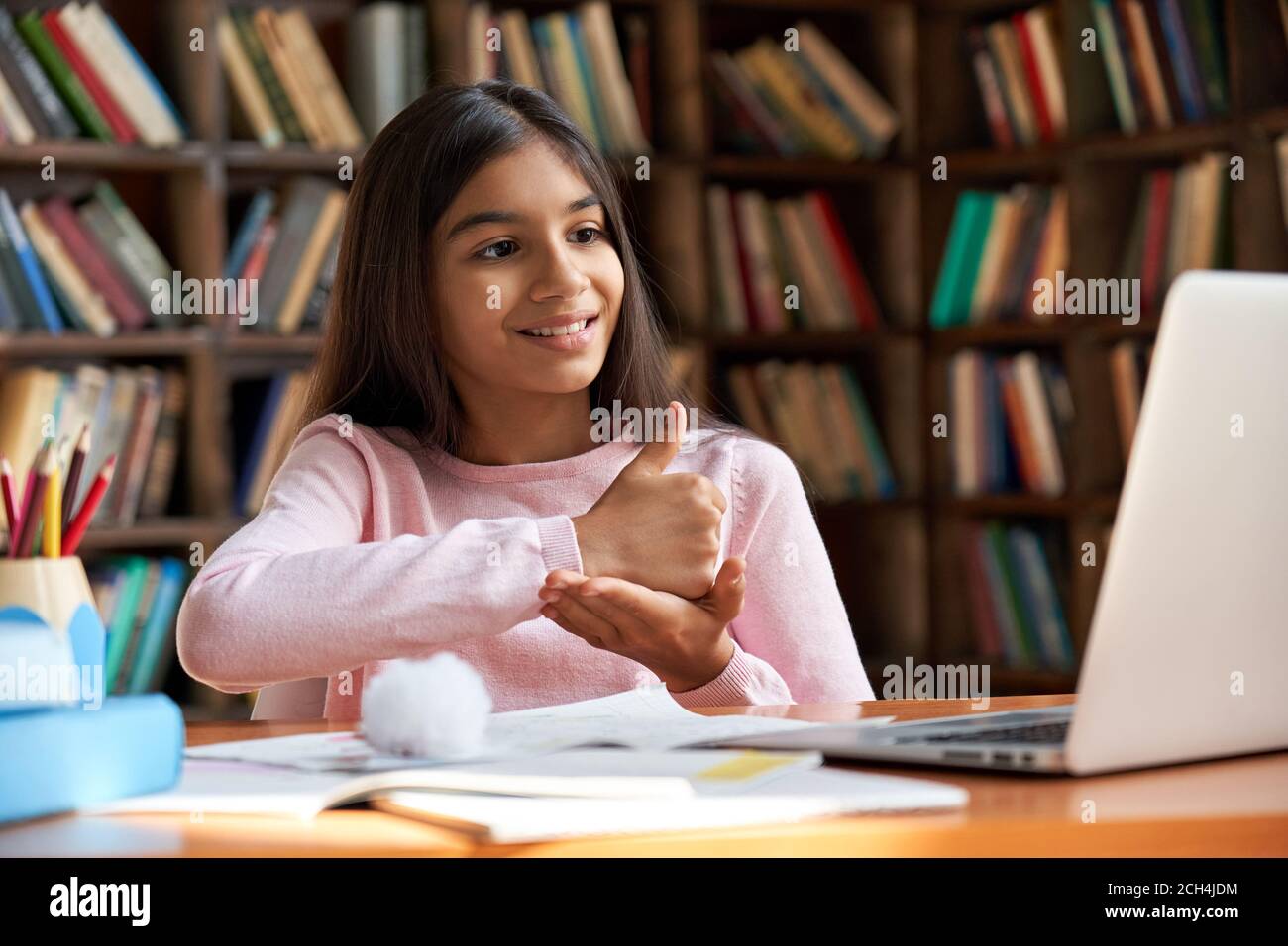School girl learning online communicating by video call using sign language. Stock Photo